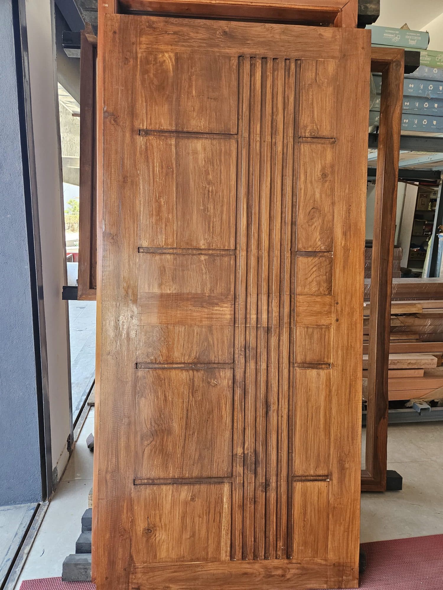 Panelled teak door shutter with a fluted centre stile, finished in the workshop