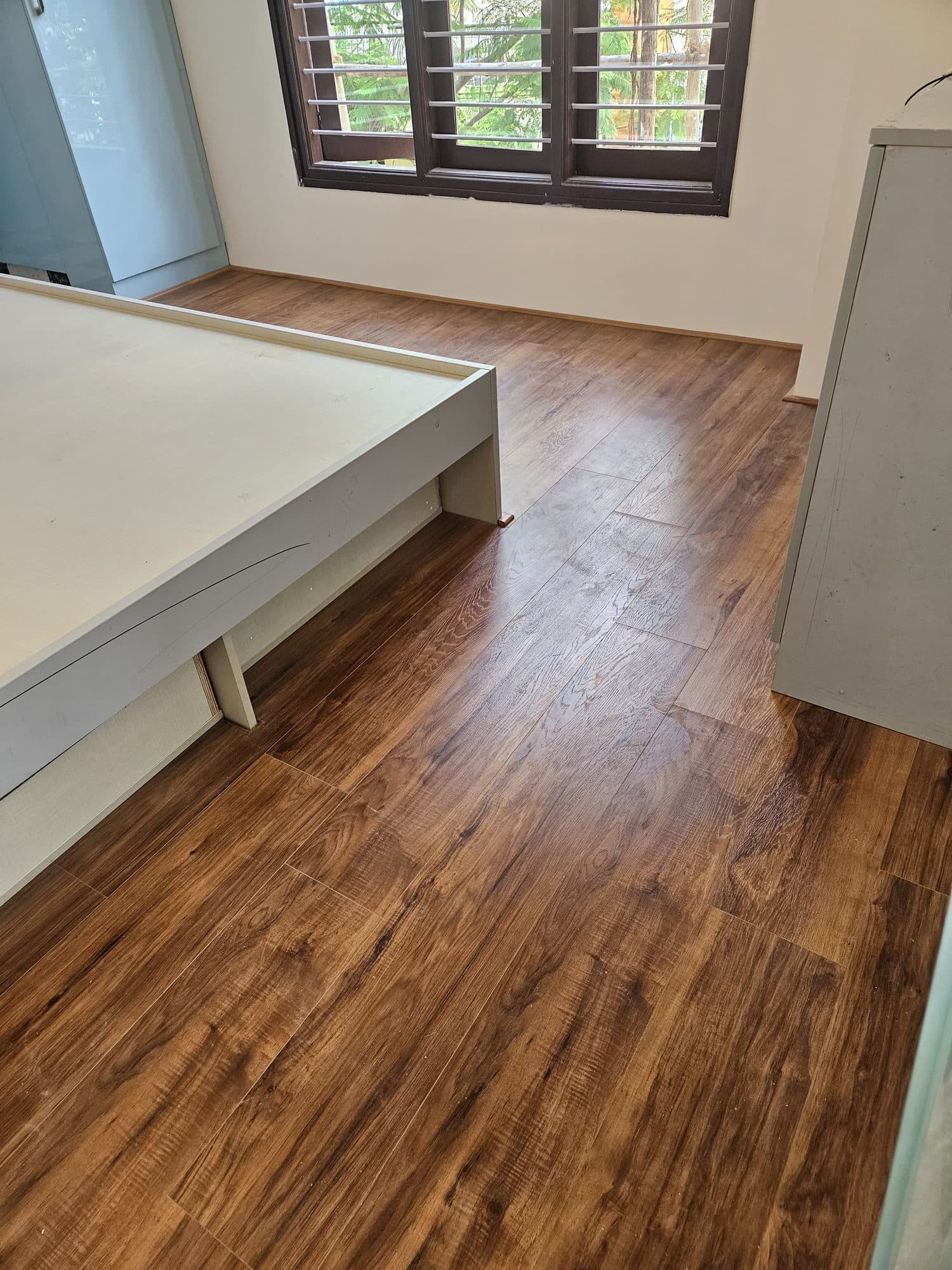 WPC and laminate wooden flooring laid in a bedroom with matching beading